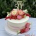 Geburtstagstorte Erwachsene - Weiße Rosen mit rosa Spitzen sind neben Beeren und Makarons der Blickfang der Torte.