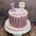 Geburtstagstorte Mädchen - Weißes Kätzchen mit rosa Schleife sitzt neben der großen Zahl auf der bunt verzierten Torte.