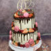 Geburtstagstorte Erwachsene - Zarte Schokotropfen verzieren diesen Drip Cake auf dem sich noch Früchte und rosa Macarons befinden.