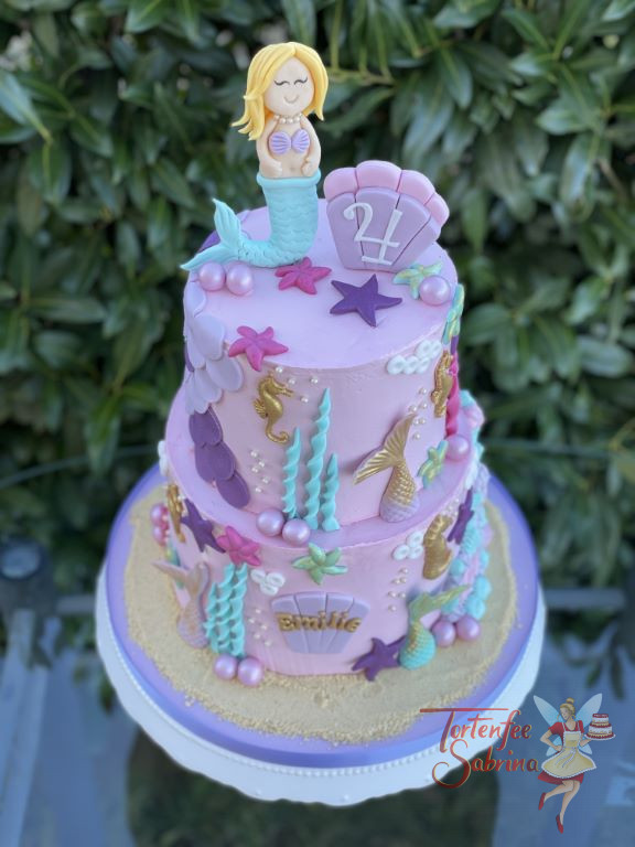 Geburtstagstorte Mädchen - Glückliche Meerjungfrau sitzt ganz oben auf der Torte neben einer Muschel mit der Geburtstagszahl.