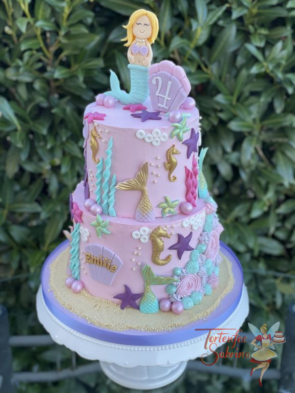 Geburtstagstorte Mädchen - Glückliche Meerjungfrau sitzt ganz oben auf der Torte neben einer Muschel mit der Geburtstagszahl.