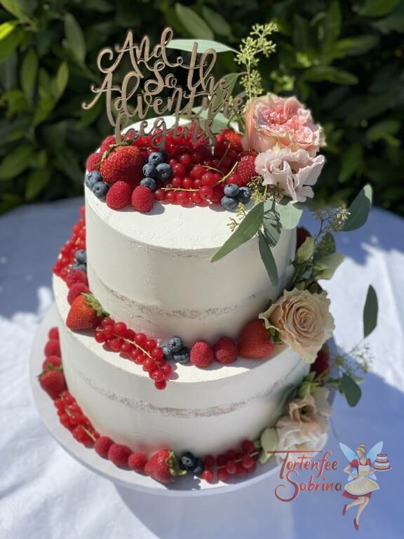 Hochzeitstorte - And the Adventure begins steht auf dem persönlichen Cake Topper, die Torte wurde noch mit Früchten und Blumen verziert.