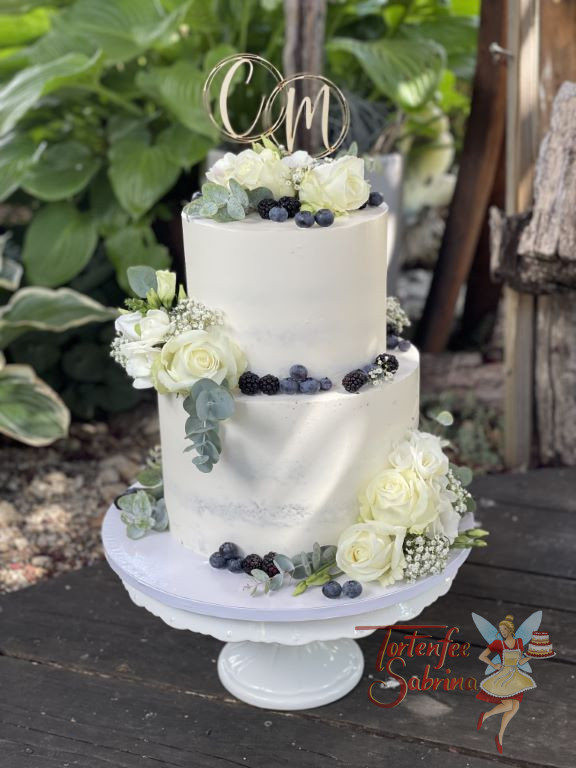 Hochzeitstorte - Beeren und Eukalyptus verzieren neben den weißen Rosen die Torte und ganz oben ist der Caketopper aus Holz.