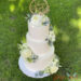 Hochzeitstorte - Bezaubernde Blumen in weißer Farbe zieren neben dem personalisiertem Caketopper die dreistöckige Torte.