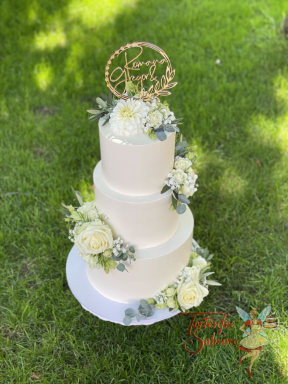 Hochzeitstorte - Bezaubernde Blumen in weißer Farbe zieren neben dem personalisiertem Caketopper die dreistöckige Torte.