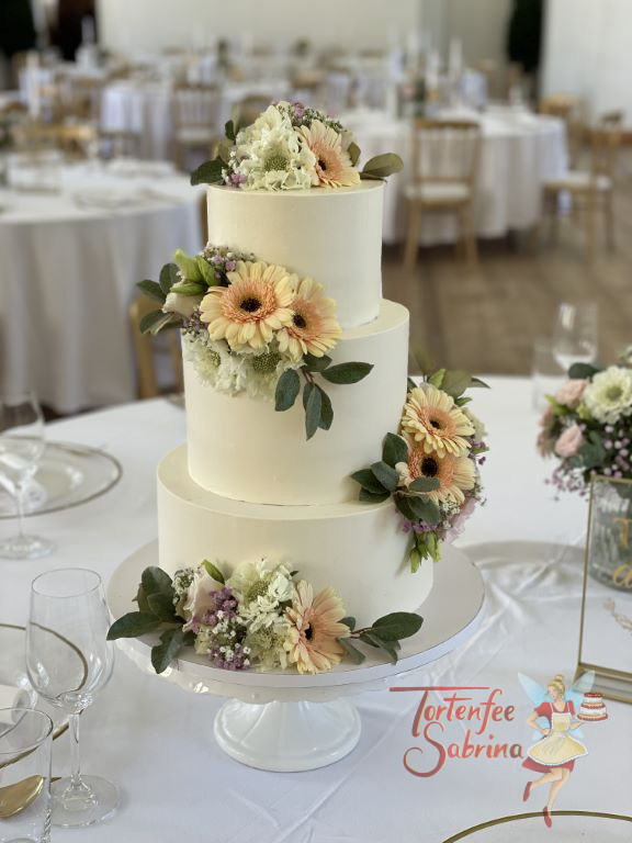 Hochzeitstorte - Blumen in zarten Farben und mit feinen Blättern zieren die dreistöckige Torte und werden zum Blickfang.