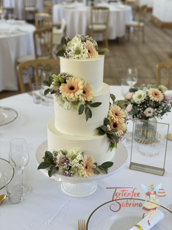 Hochzeitstorte - Blumen in zarten Farben und mit feinen Blättern zieren die dreistöckige Torte und werden zum Blickfang.