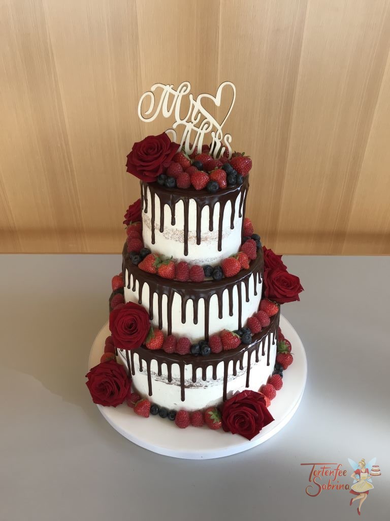 Hochzeitstorte - Blumen und Berren, dieser Drip Cake mit dunkler Schokolade wurde mit roten Rosen und verschiedenen Berren verziert.