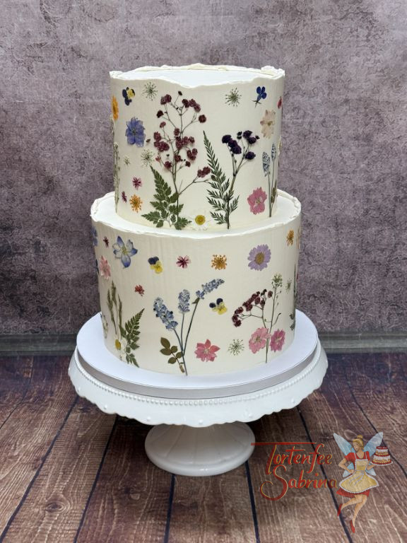 Hochzeitstorte - Bunte Blumen von der Blumenwiese wurden rundherum auf der ganzen zweistöckigen Torte platziert.