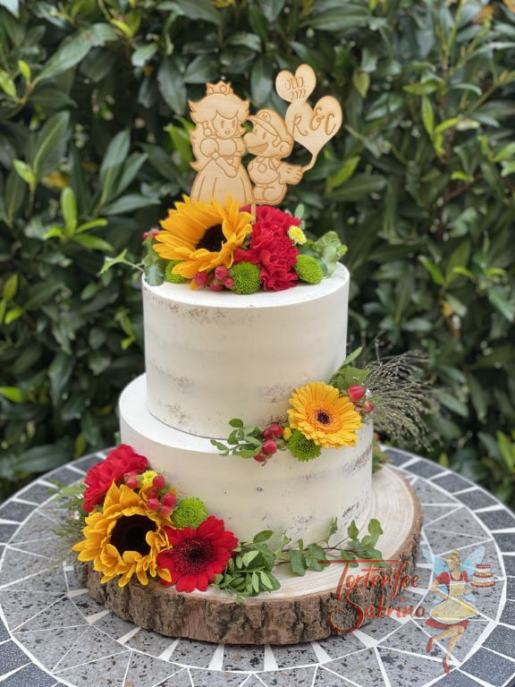 Hochzeitstorte - Daisy und Super Mario sind hier bei diesem angefertigten Caketopper zu sehen umgeben von bunten Blumen.