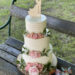 Hochzeitstorte - Das verliebte Brautpaar ist hier als Caketopper auf der mit Rillen und Blumen verzierten dreistöckigen Torte.