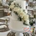 Hochzeitstorte - Das weiße Blumenband aus Rosen und Lavendel ziert den mittleren Teil der weiß eingestrichenen Torte.