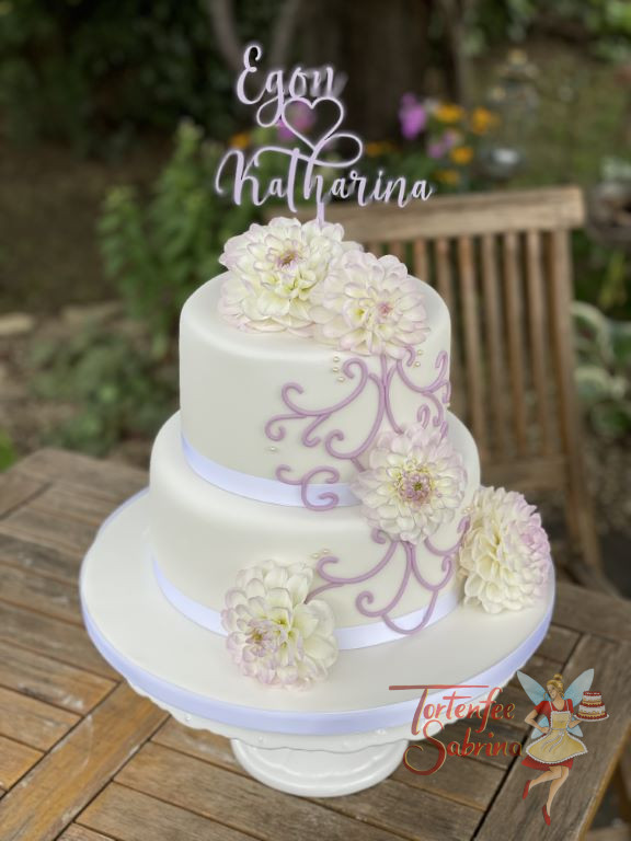 Hochzeitstorte - Das zarte lila Muster wurde in dünnen Linien auf die Torte aufgebracht und von dem Blumenschmuck umrahmt.