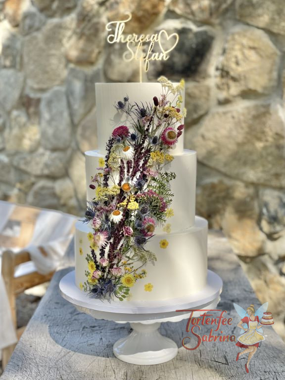 Hochzeitstorte - Der Wildblumenstrauß wurde liebevoll aus einzeln getrockneten Wiesenblumen auf der plaziert.