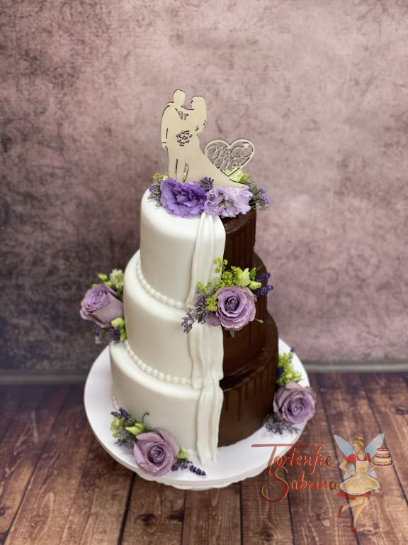 Hochzeitstorte - Die halbe Torte ist ein Drip Cake und die andere Hälfte wurde weiss eingedeckt und mit lila Rosen verziert.
