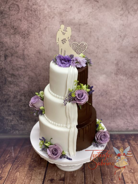 Hochzeitstorte - Die halbe Torte ist ein Drip Cake und die andere Hälfte wurde weiss eingedeckt und mit lila Rosen verziert.