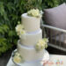 Hochzeitstorte - Edel in weiß erscheint hier die Torte, der Abschuß wurde mit zarten Bändern hergestellt und mit Blumen geschückt.