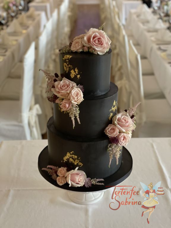 Hochzeitstorte - Ein Traum in Schwarz mit rosa Rosen und dezent aufgebrachten glänzendem Blattgold verziert die Torte.