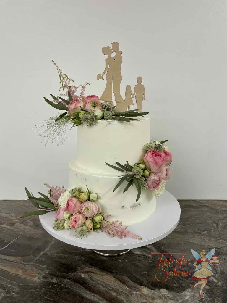Hochzeitstorte - Familie mit Blumen zeigt eine Torte mit einem schönen Holz-Topper und schönen Rosen in weiß und rosa.
