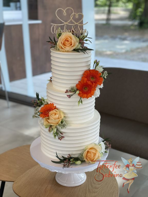 Hochzeitstorte - Geschwungene Herzen verzieren ganz oben in Form des Caketoppers die dreistöckige mit Rillen angefertige Torte.