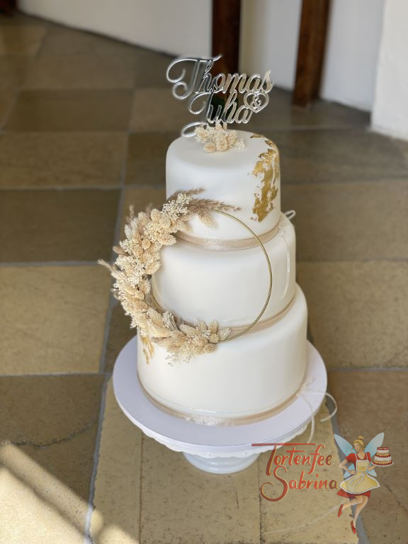Hochzeitstorte - Gold mit Trockenblumen auf einen Ring geflochten sind der Blickfang dieser dreistöckigen Torte.
