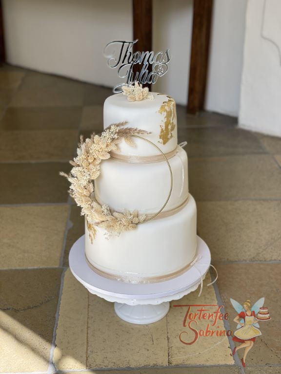 Hochzeitstorte - Gold mit Trockenblumen auf einen Ring geflochten sind der Blickfang dieser dreistöckigen Torte.