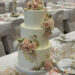 Hochzeitstorte - Goldene Akzente wurden mit Blattgold dargestellt, sie heben den rosa Blumenschmuck besonders hervor.