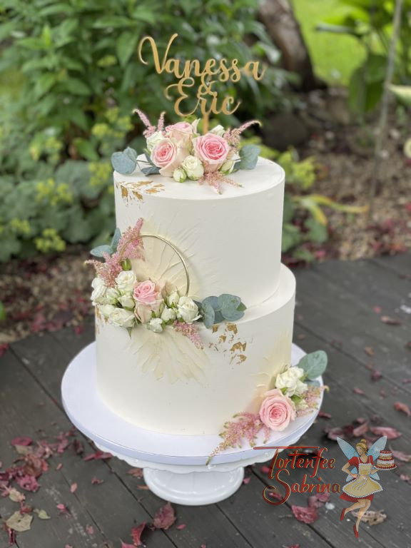 Hochzeitstorte - Goldender Ring und Rosen verzieren neben dem Blattgold und dem cremfarbenen Muster die zweistöckige Torte.