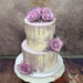 Hochzeitstorte - Große lila Rosen verzieren neben dem passenden Drip die zweistöckige Torte gekrönt von einem Caketopper.