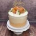 Hochzeitstorte - Große und kleine Perlen verzieren neben den Blumen und dem Caketopper die mehrfärbige Torte.