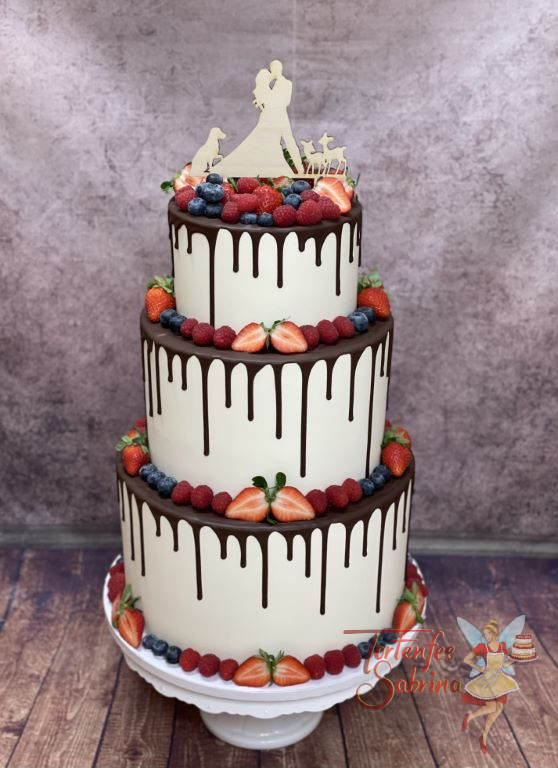 Hochzeitstorte - Köstliche Beeren in unterschiedlichen Farben verzieren diesen Schoko-Drip Cake mit Caketopper.