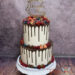 Hochzeitstorte - Köstliche Früchte, wie Erdbeeren und Himbeeren verzieren neben den Schokoherzen den zweistöckigen Drip Cake.