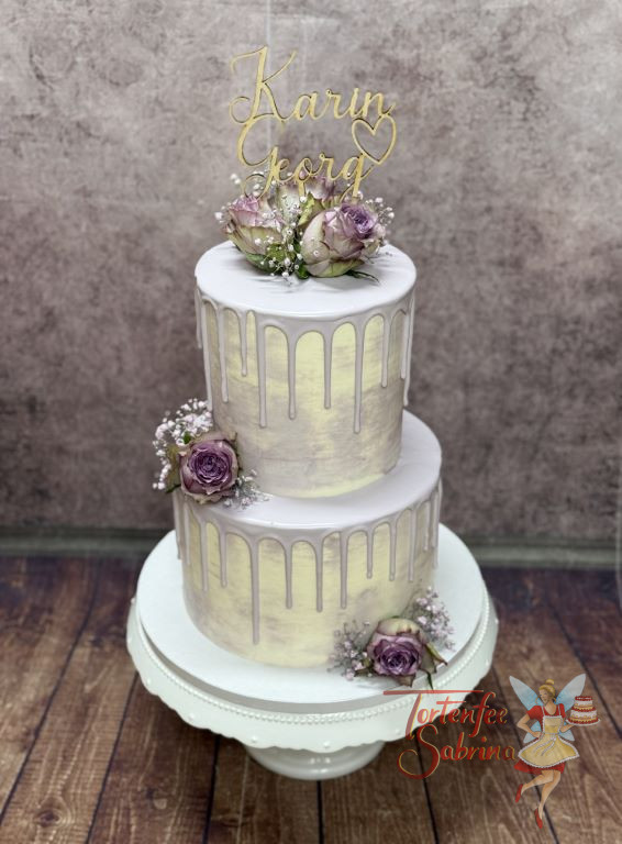 Hochzeitstorte - Lila Drip über zwei Etagen verziert neben den passenden Rosen und dem personalisierten Caketopper die Torte.