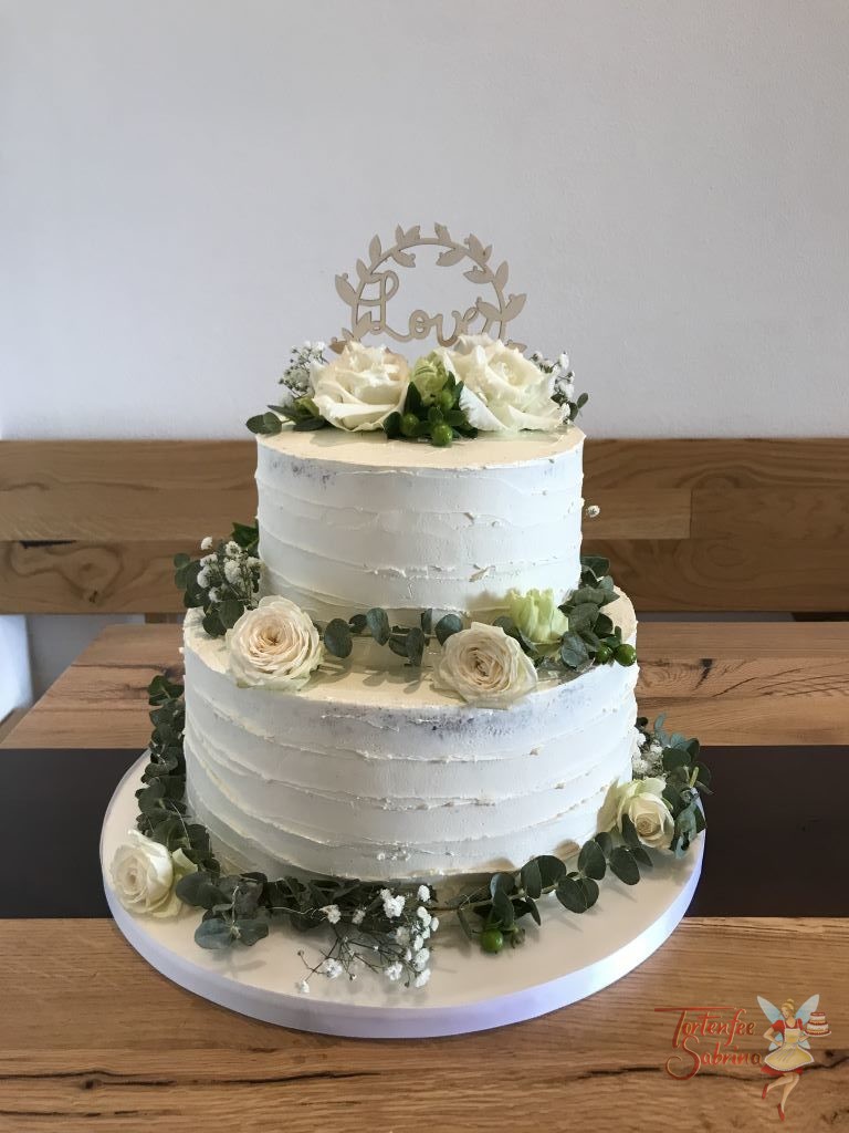 Hochzeitstorte - Love mit Blumengirlande, die Torte wurde mit einem Rillenmuster eingestricken und einem Topper gekrönt.