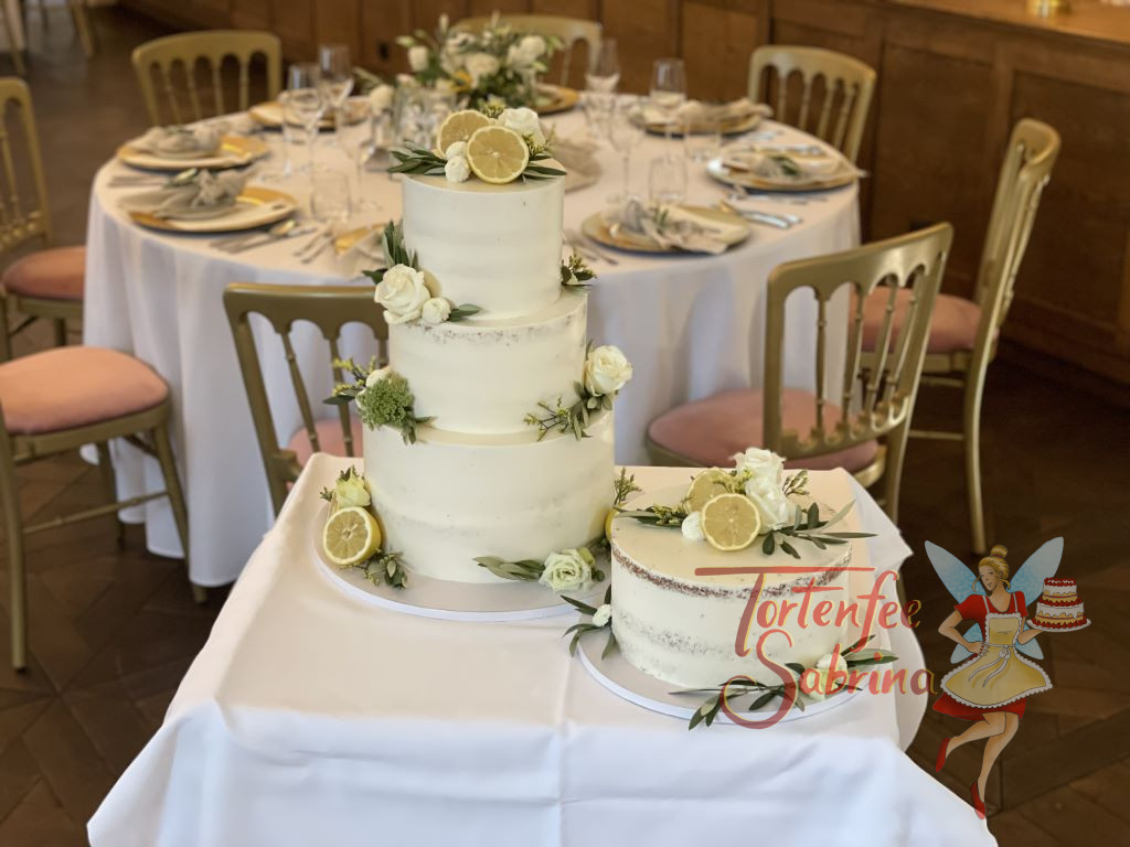 Hochzeitstorte - Olivenzweige treffen auf Zitronen und weiße Blumen, in diesem Design wurde die Haupttorte und die Beitorte verziert.