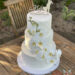 Hochzeitstorte - Orchideenblüten mit glänzendem perlmutfarbenem Muster. Entlang der Torte rankt sich ein ganzer Orchideenstamm.