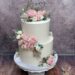 Hochzeitstorte - Perfektes goldenes Herz ist neben den Namen Teil des Caketoppers, Blickfang ist der üppige Blumenschmuck mit Rosen.