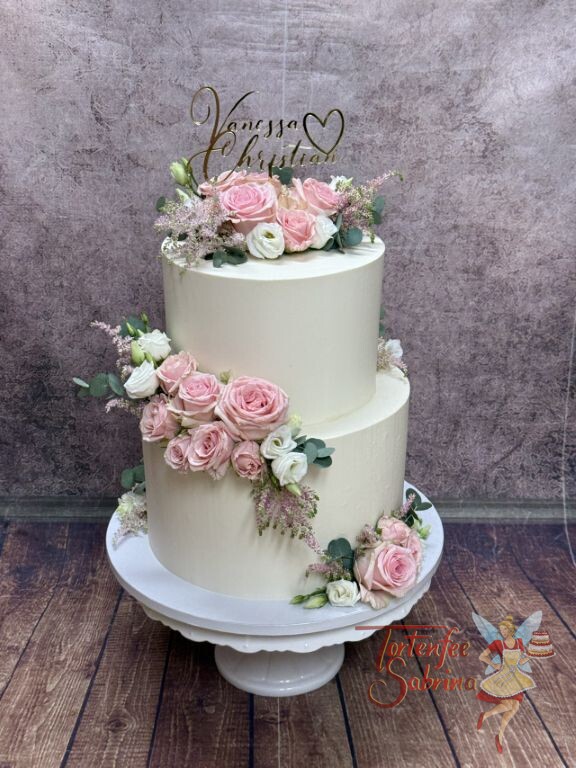 Hochzeitstorte - Perfektes goldenes Herz ist neben den Namen Teil des Caketoppers, Blickfang ist der üppige Blumenschmuck mit Rosen.