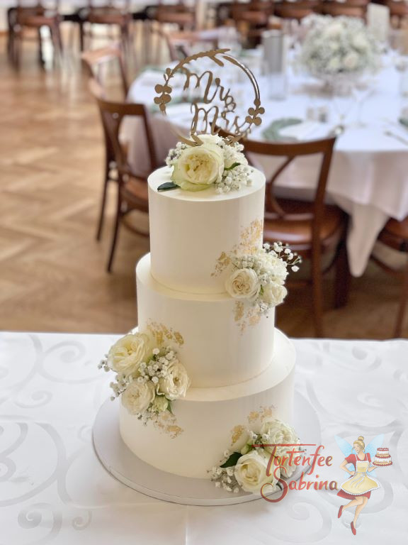 Hochzeitstorte - Prächtige Rosen umgeben von Blattgold zieren neben dem goldenen Caketopper die weiße Torte.