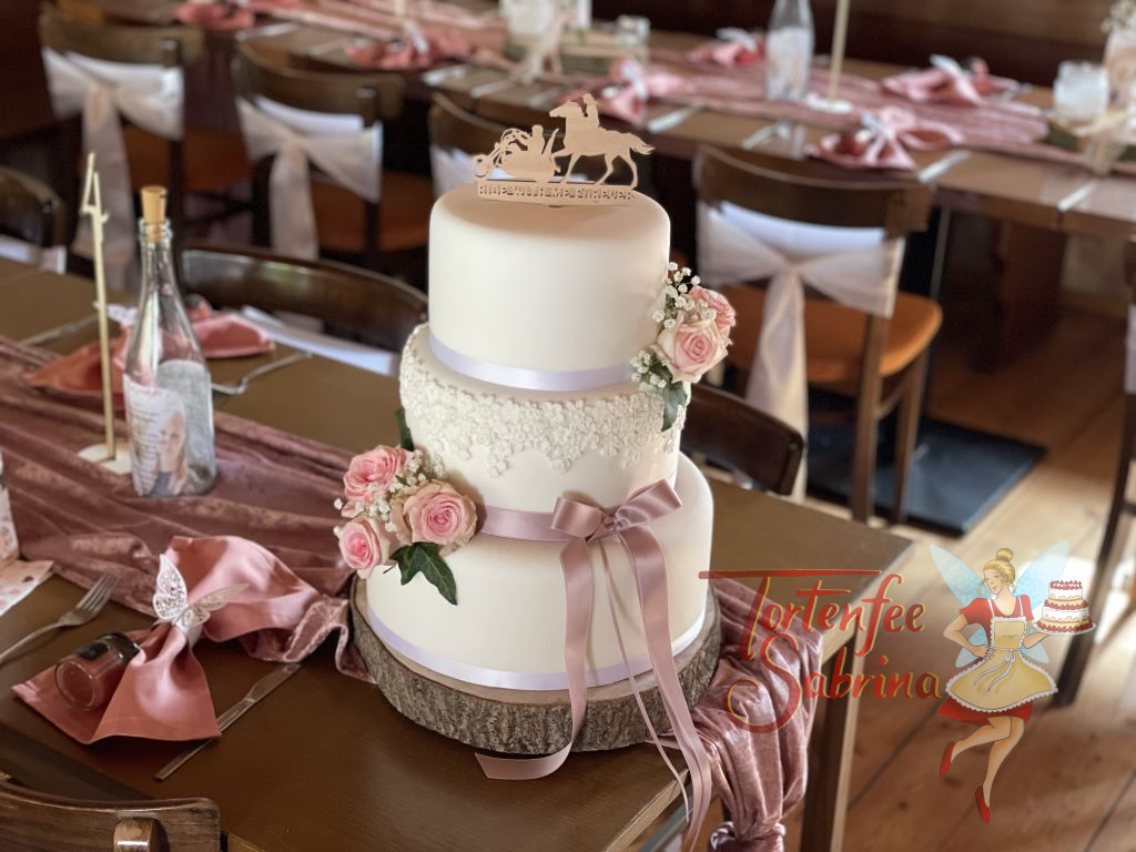 Hochzeitstorte - Ride with me forever steht auf dem Caketopper aus Holz, die Torte wurde noch mit Blumen und Bändern verziert.