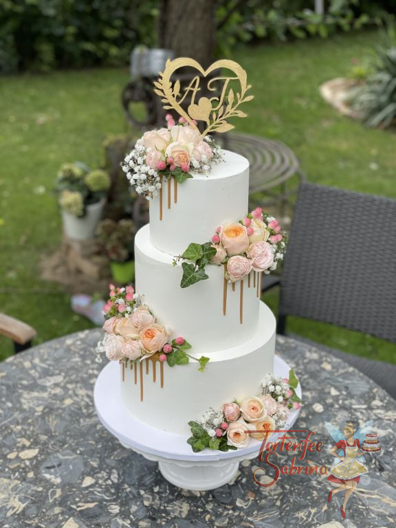 Hochzeitstorte - Rosa trifft auf Gold, hier wurde die Torte mit roas Rosen und Efeu sowie mit einem goldenen Drip veredelt.