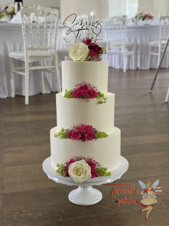 Hochzeitstorte - Rose in der Mitte verziert den untersten Stock der dreistöckigen Hochzeitstorte mit Caketopper.