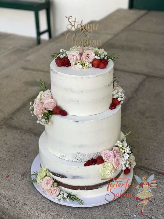 Hochzeitstorte - Rosen vereint mit Beeren und verschönern diese Hochzeitstorte. Ganz oben auf der Torte ist ein personalisierter Caketopper.