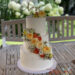 Hochzeitstorte - Rosenband mit Muster aus Buttercreme, ganz oben auf der Torte verziert ein Caketopper und Rosen den obersten Teil.