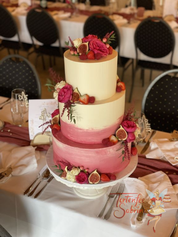Hochzeitstorte - Rote Beerentöne zieren die unteren beiden Etagen der Torte. Die Torte wurde mit Früchten und Blumen verziert.