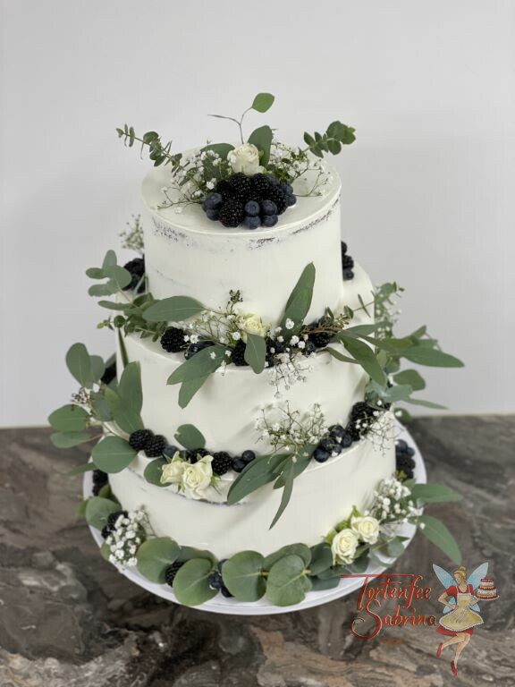 Hochzeitstorte - Viele blaue Beeren und Blätter verschönern die schlichte weiße Torte, ebenfalls auf der sind weiße Rosen.