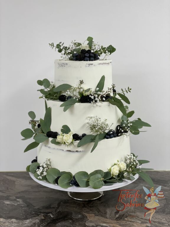 Hochzeitstorte - Viele blaue Beeren und Blätter verschönern die schlichte weiße Torte, ebenfalls auf der sind weiße Rosen.