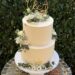 Hochzeitstorte - Weiße Blüten mit Blattgold verzieren neben dem goldenen Caketopper mit den Anfangsbuchstaben die Torte.
