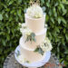Hochzeitstorte - Weiße Blütenpracht verziert neben dem Caketopper ganz oben aus Holz die dreistöckige Torte.