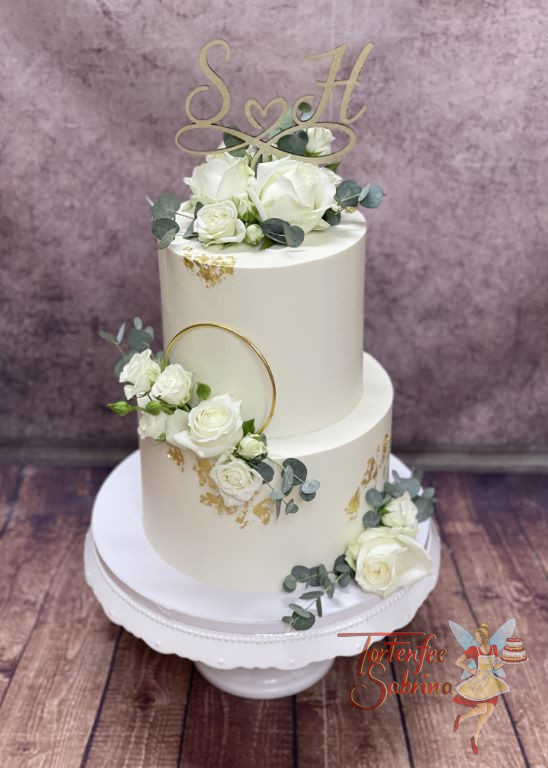 Hochzeitstorte - Weiße Rosen mit goldenem Ring und Blattgold verzieren die weiße zweistöckige Torte mit Caketopper.